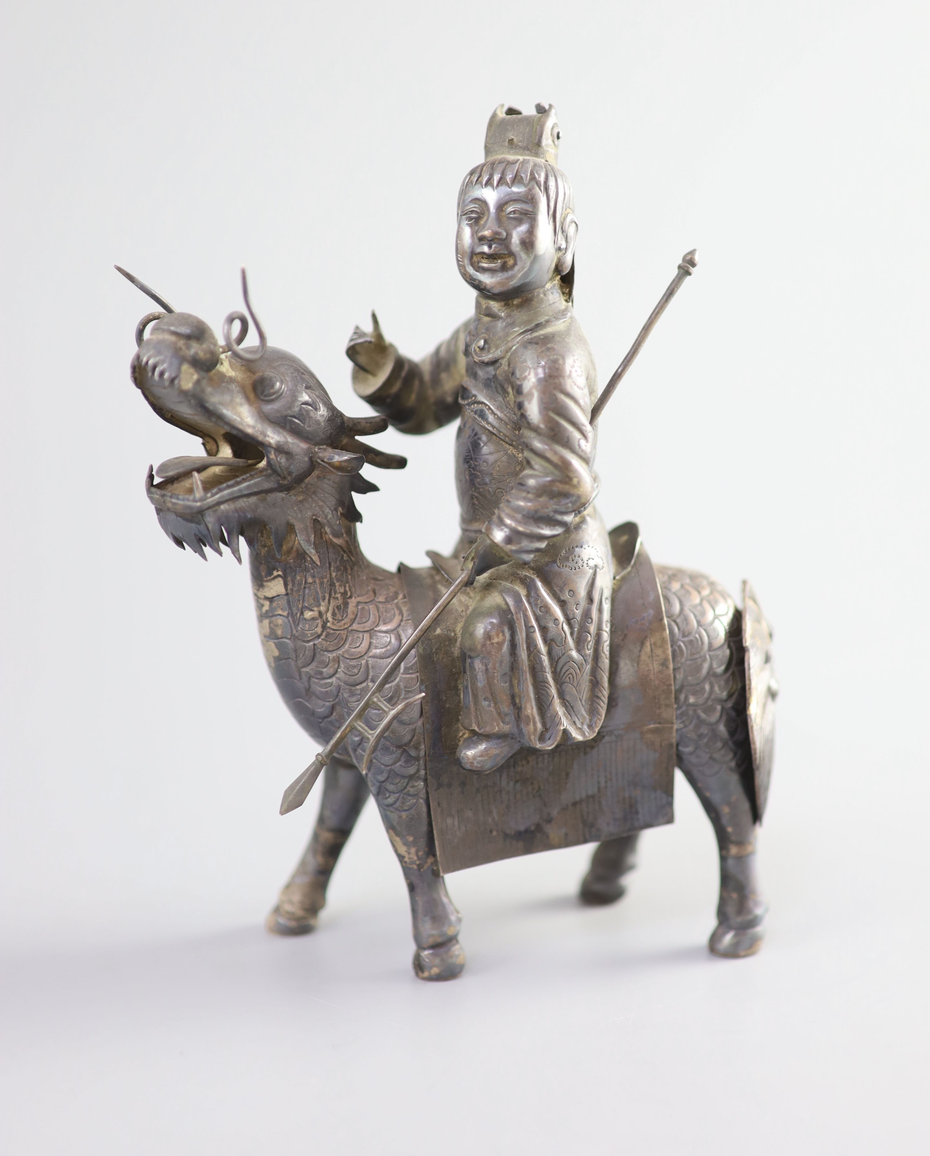 A Chinese white metal model of a boy riding a qilin , early 20th century, 12.5cm long